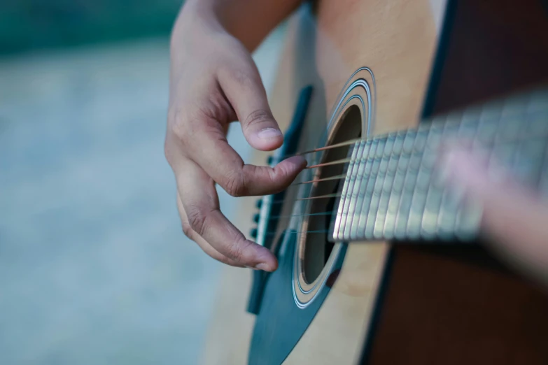 a close up of a person playing a guitar, by Alejandro Obregón, pexels contest winner, 15081959 21121991 01012000 4k, instagram post, detailed skin, outside intricate