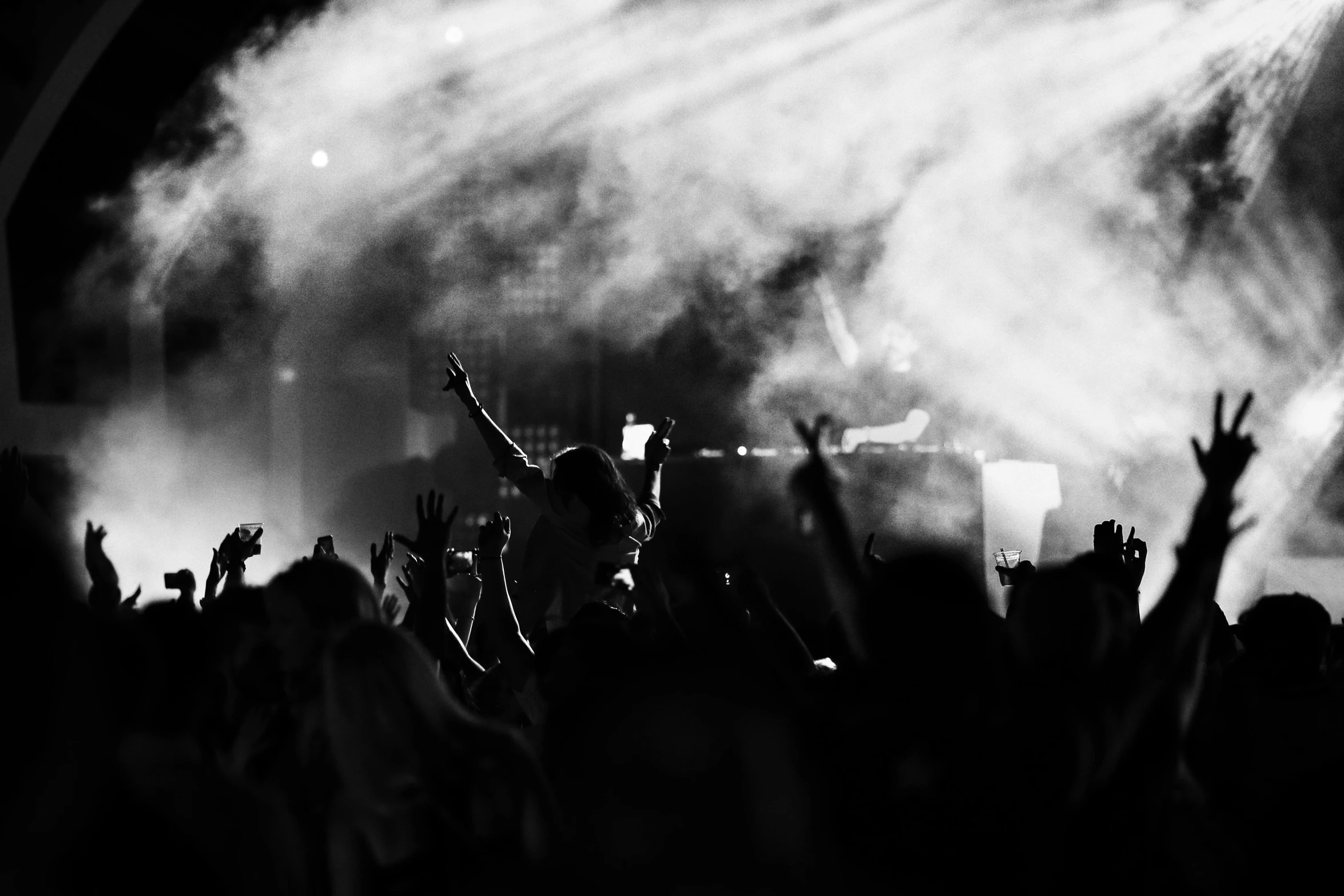 a crowd of people standing in front of a stage, a black and white photo, pexels, trance music, thumbnail, waving, nigth