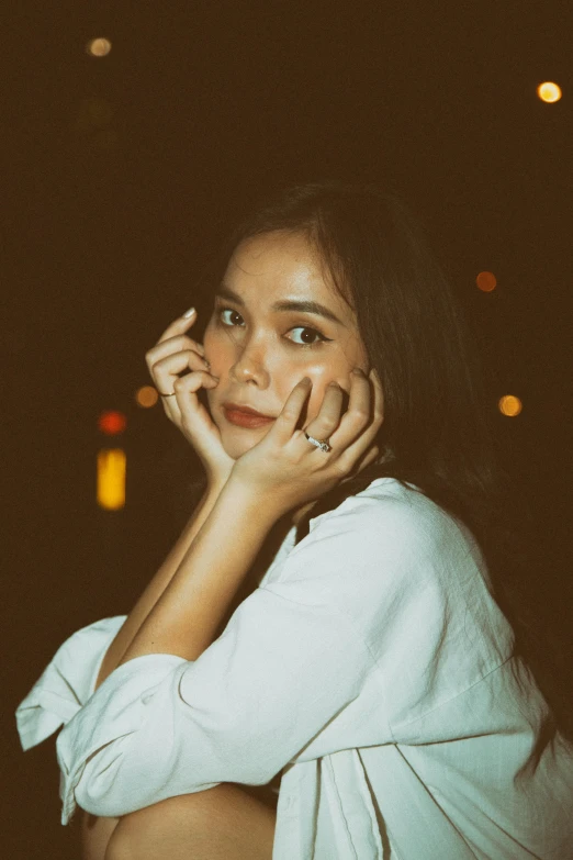 a woman in a white shirt talking on a cell phone, by Basuki Abdullah, pexels contest winner, portrait of jossi of blackpink, rings, during night, lovingly looking at camera