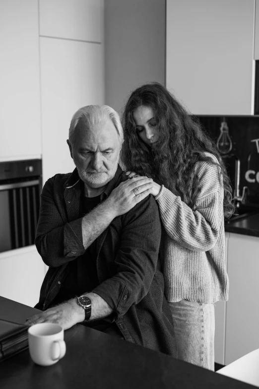 a man standing next to a woman in a kitchen, a black and white photo, by Adam Marczyński, pexels contest winner, photorealism, portrait of hide the pain harold, hugging her knees, 15081959 21121991 01012000 4k, daughter