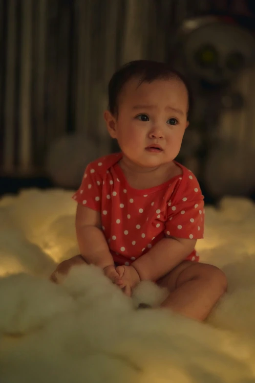 a baby sitting on a bed in a room, by Yosa Buson, red and cinematic lighting, sitting in a fluffy cloud, promo image, concerned