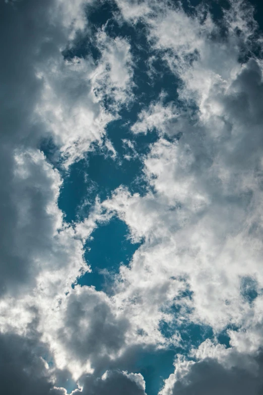 a plane flying through a cloudy blue sky, inspired by Elsa Bleda, trending on unsplash, portrait photo, cloud nebula, 2019 trending photo, looking up