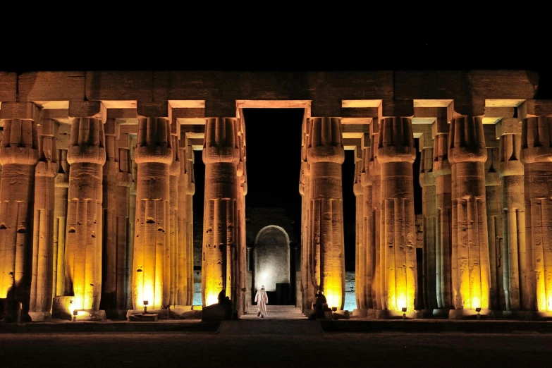 a large building with columns lit up at night, egyptian art, pexels contest winner, fan favorite, promo image, geometry, delightful surroundings