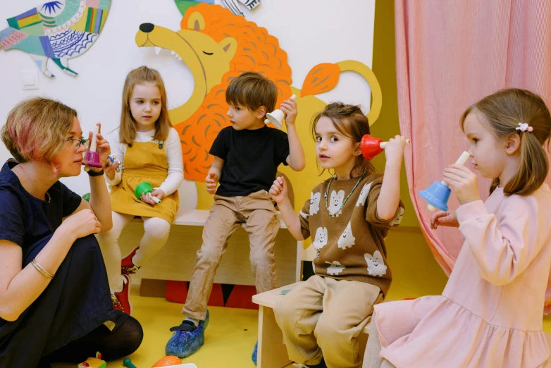 a group of children sitting on top of a yellow floor