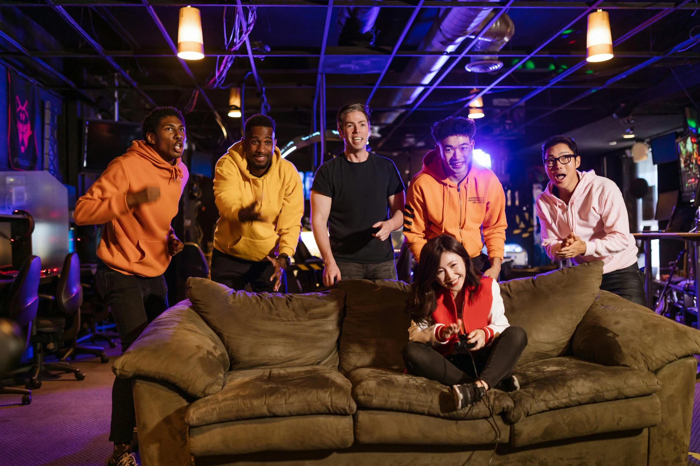 a group of people standing around a couch, pokimane, neon basement, commercial, in house