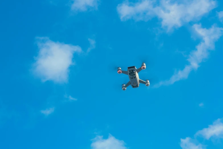 a white drone flying through a blue sky, by Niko Henrichon, unsplash, square, flying toasters in heaven, toys, high - angle view