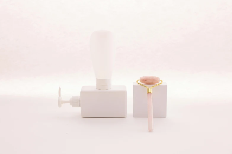 a couple of toothbrushes sitting on top of a white box, a marble sculpture, by Emma Andijewska, art nouveau, pink and gold color scheme, soap bubble, with electric arc device, round bottle