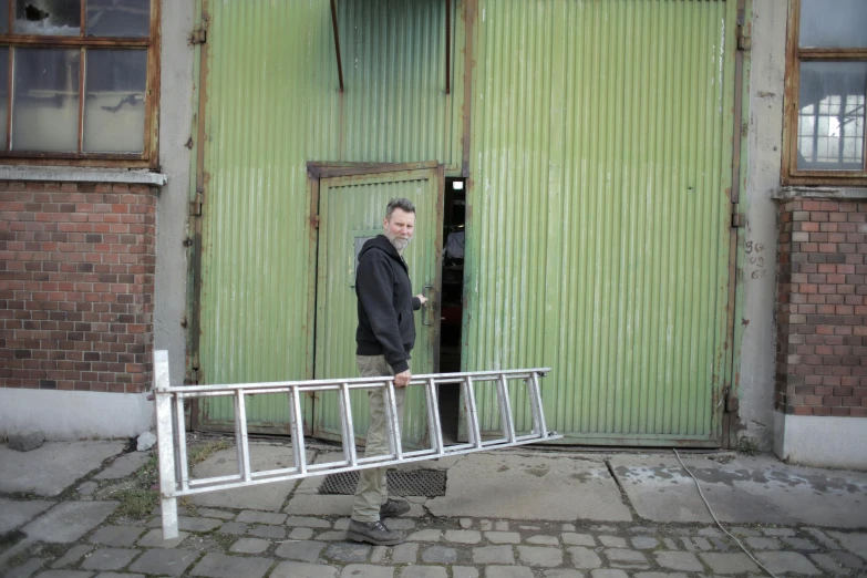 a man standing in front of a green door, by Jan Tengnagel, temporary art, ladder, foundry vtt, white metal, dingy