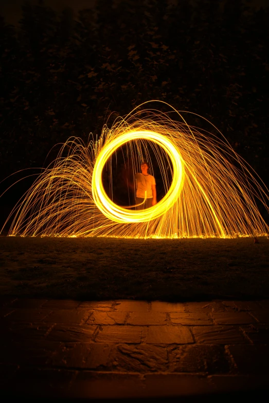 a person standing in front of a circle of fire, by Dan Content, pexels contest winner, interactive art, golden spirals, sparkling, low iso, relaxing