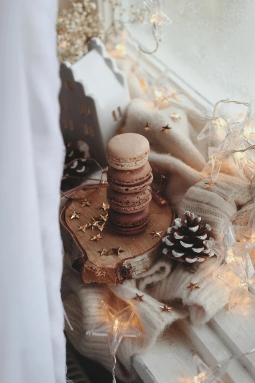 a pile of cookies sitting on top of a window sill, a picture, by Julia Pishtar, pexels contest winner, romanticism, fairy lights, macaron, small crown, (3 are winter