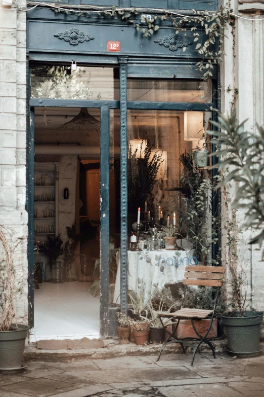 a building with a bunch of potted plants in front of it, a photo, trending on unsplash, renaissance, doorway, cafe interior, a still of an ethereal, bakery