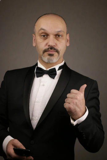 a man in a tuxedo giving a thumbs up, an album cover, inspired by Edi Rama, reddit, headshot photo, in a fighting stance, adar darnov, professional photo-n 3