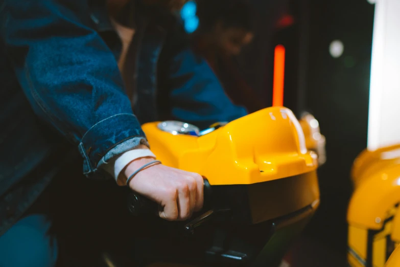 a close up of a person playing a video game, by Julia Pishtar, trending on unsplash, bumper cars, yellow, wooden, 7 0 s photo