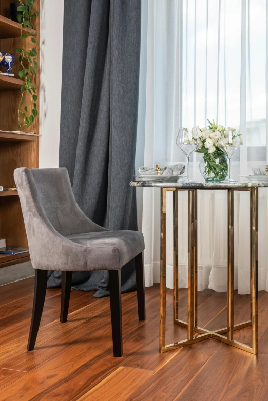 a chair sitting next to a table on top of a hard wood floor, featured on pinterest, grey and gold color palette, fine dining, upscaled to high resolution, apartment