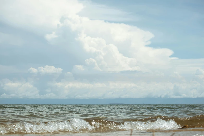 a person flying a kite on top of a sandy beach, giant cumulonimbus cloud, near lake baikal, slide show, thumbnail