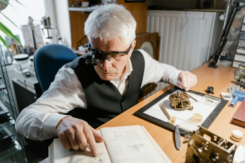 a man sitting at a desk in front of a book, silver monocle, local conspirologist, looking at the treasure box, with navigator shaped glasses
