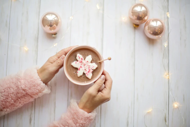 a person holding a cup of hot chocolate with marshmallows, a photo, by Julia Pishtar, trending on pexels, seven pointed pink star, decorations, etsy, rose gold