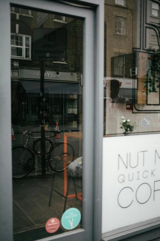 a sign in the window of a coffee shop, by Nick Fudge, trending on unsplash, nut, seen from behind, neutral background, in london