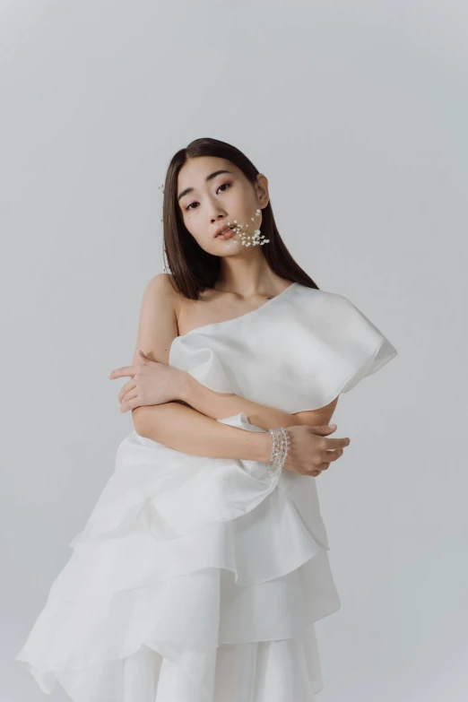a woman in a white dress posing for the camera, an album cover, inspired by Wen Jia, trending on pexels, jewelry, ruffles, white backround, lily frank