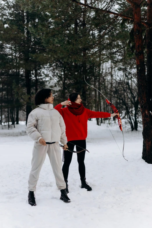 two people are flying a kite in the snow, by Julia Pishtar, pexels contest winner, visual art, woman holding recurve bow, russian style, instagram story, at a park