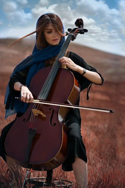 a woman playing a cello in a field, inspired by Anka Zhuravleva, unsplash, arabesque, avatar image, islamic, no cropping, cinematic”