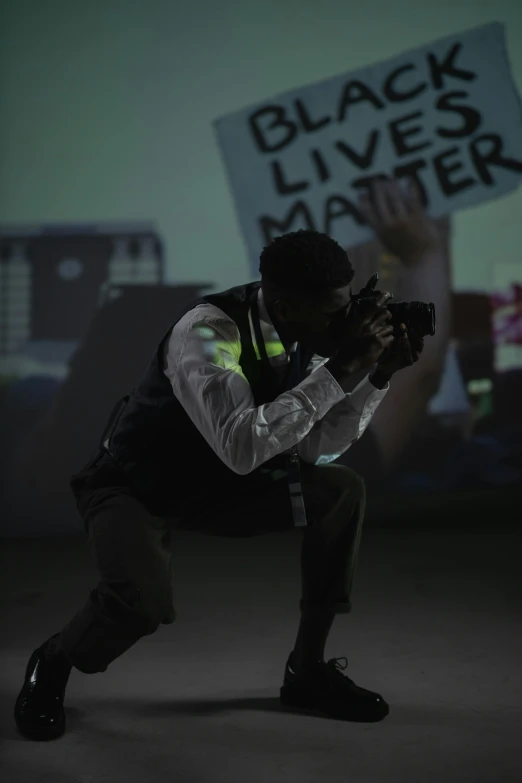 a man holding a sign that says black lives matter, a picture, video art, full body profile camera shot, in an action pose, projection mapping, cop
