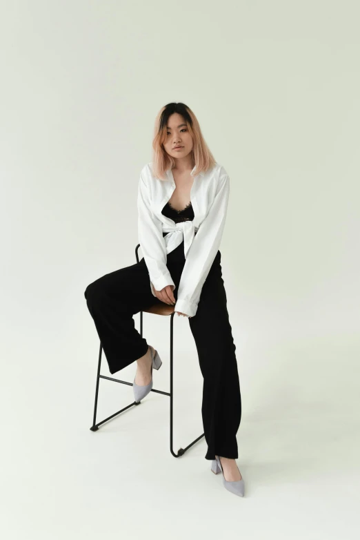 a woman sitting on a chair in a white shirt and black pants, inspired by Feng Zhu, trending on unsplash, wide full body, cropped wide sleeve, pastel', asian female