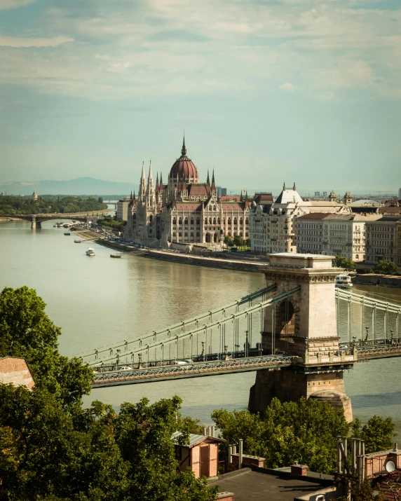 a bridge over a river with a building in the background, by Matija Jama, pexels contest winner, renaissance, austro - hungarian, hills in the background, slide show, parliament