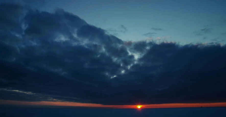 the sun is setting on the horizon of the ocean, by Andrei Kolkoutine, pexels contest winner, romanticism, below only cloud dark void, view above the clouds, grey, today\'s featured photograph 4k