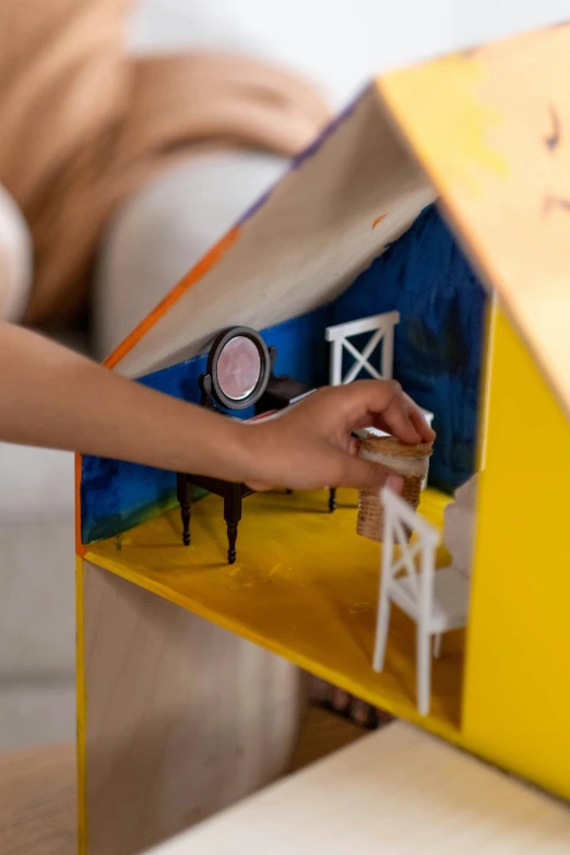 a close up of a person playing with a doll house, by Julia Pishtar, conceptual art, children's artwork, teaser, product design shot, inspect in inventory image