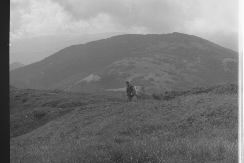 a black and white photo of a person on a horse, sōsaku hanga, grassy hills, trecking, wartime footage, colin searle