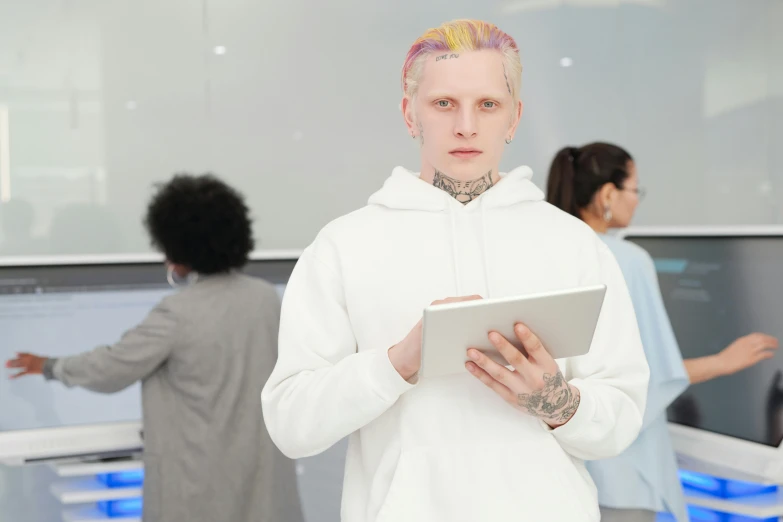 a man in a white hoodie holding a tablet, inspired by Seb McKinnon, trending on pexels, cyberpunk dyed haircut, in intergalactic hq, albino, a person standing in front of a