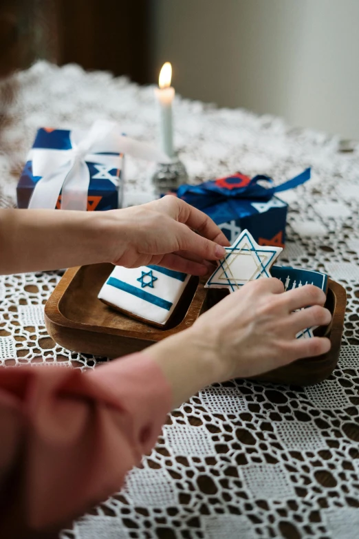 a couple of people that are sitting at a table, dau-al-set, holding gift, blue and white, geometric, pray