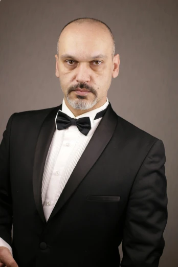 a man in a tuxedo posing for a picture, inspired by Edi Rama, rugged man portrait, vitaliy bondarchuk, medium-shot, uploaded