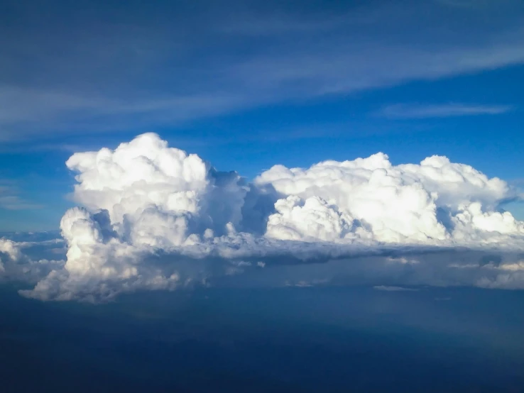 a blue sky filled with lots of white clouds, by Jan Rustem, unsplash, fantastic realism, high-angle, giant cumulonimbus cloud, commercial photo