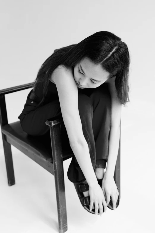 a black and white photo of a woman sitting in a chair, a black and white photo, inspired by Fei Danxu, tumblr, crying and reaching with her arm, young asian woman, bella poarch, ji-min