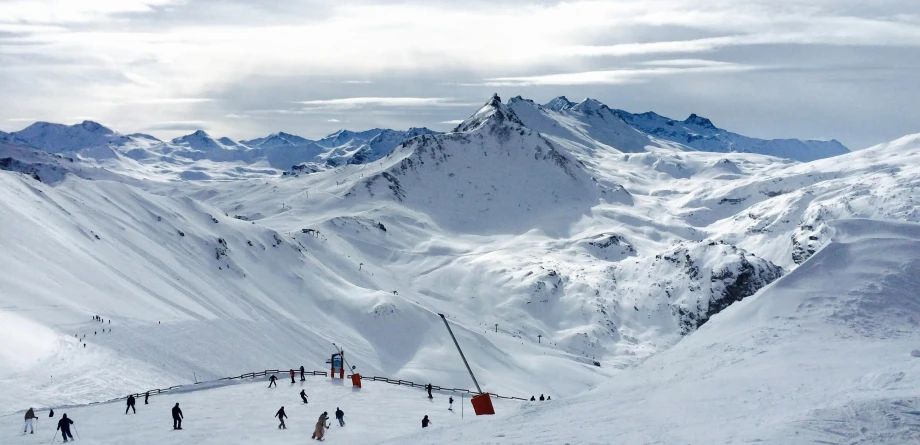 a group of people riding skis down a snow covered slope, the panorama, 1km tall, iconic scene, sloped site