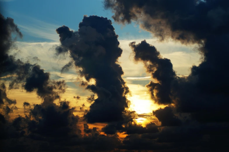 the sun is setting behind a cloud filled sky, pexels contest winner, romanticism, strange formations, cumulus, black clouds, chaotic sea setting