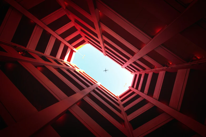 a view of the sky from the inside of a building, a photo, inspired by Beeple, pexels contest winner, volumetric lighting. red, square, drone photograpghy, four stories high