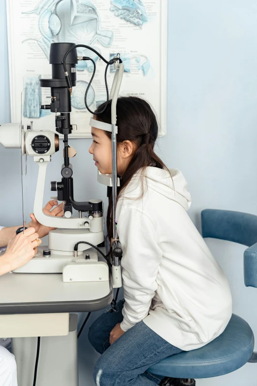 a woman getting her eye examined by a doctor, by Jang Seung-eop, trending on unsplash, children's, panoramic shot, half image, student