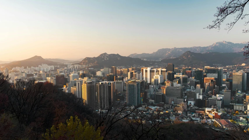 a view of a city with mountains in the background, by Jang Seung-eop, pexels contest winner, late afternoon light, sangsoo jeong, panoramic, festivals