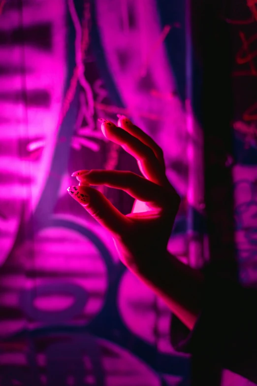 a close up of a person's hand holding a pink light, inspired by Elsa Bleda, pexels, holography, cyberpunk strip clubs, holding a cigarette, the walls purple and pulsing, hands in the air