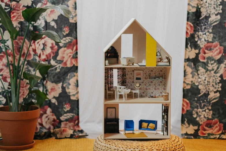 a doll house sitting on top of a table, by Julia Pishtar, unsplash, ikea style, tall, patterned, in a medium full shot