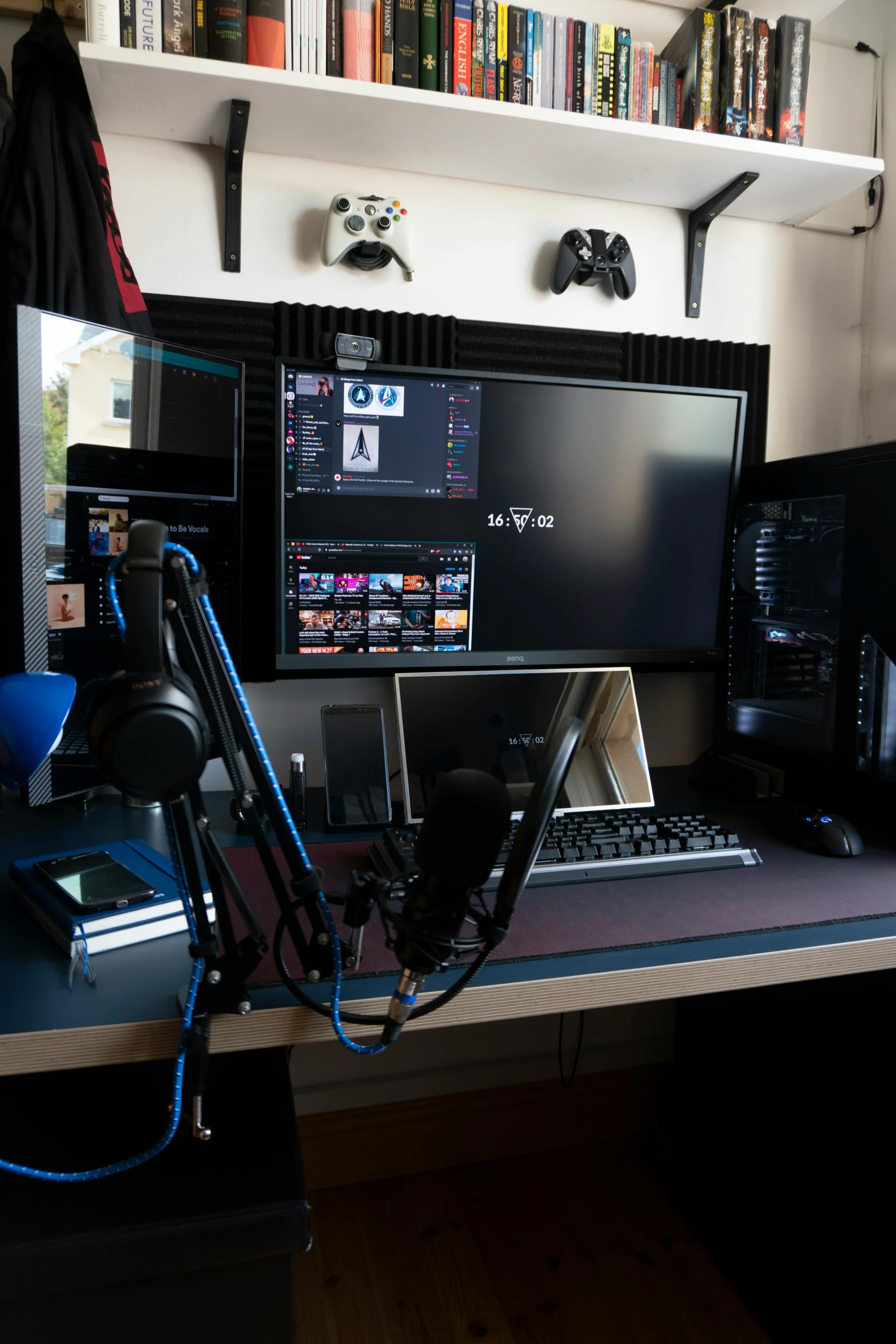 a laptop computer sitting on top of a wooden desk, gaming room, standing microphones, with screens and silks, gaming headset