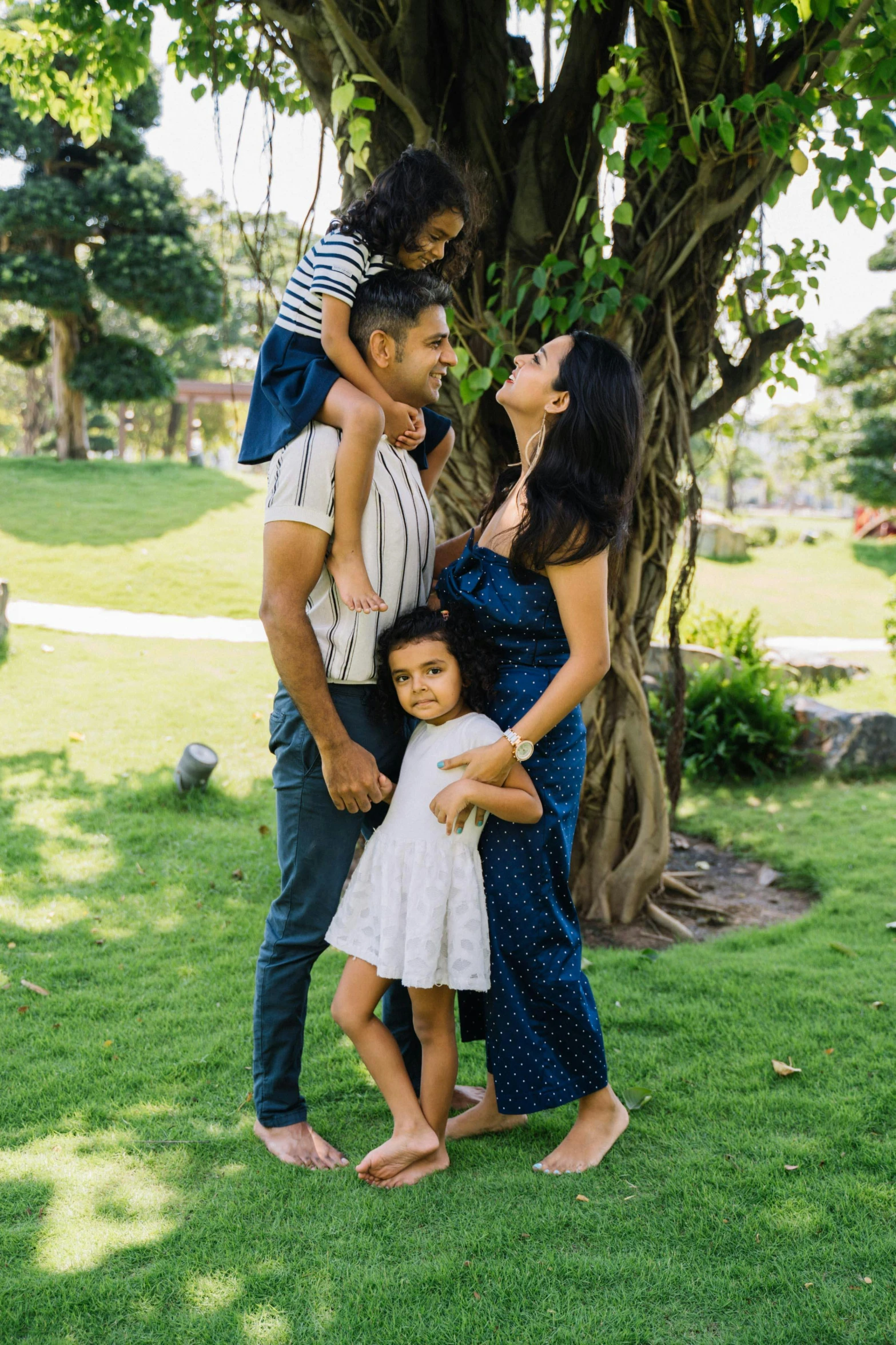 a family poses for a picture in front of a tree, pexels, freida pinto, pr shoot, singapore, square