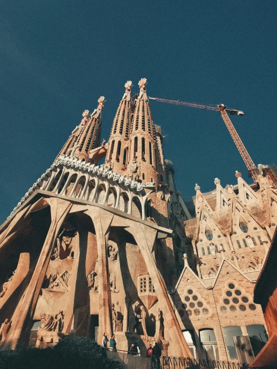 a very tall building with a crane on top of it, by Gaudi, pexels contest winner, religious, brown, instagram picture, set pieces