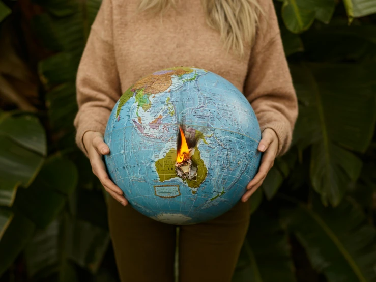 a woman holding a globe in her hands, an album cover, inspired by national geographic, trending on pexels, environmental art, small people with torches, top down shot, ultra realistic, colour photo