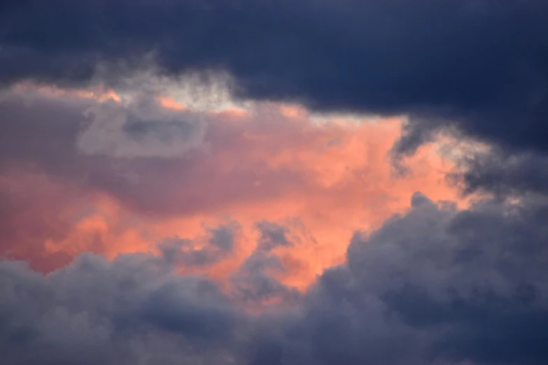 a plane flying through a cloudy sky at sunset, by Neil Blevins, unsplash, pink storm clouds, a close-up, cumulus, pink