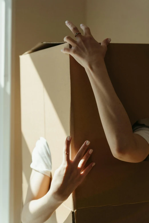 a woman holding a cardboard box over her head, pexels contest winner, soft internal light, opening door, 4l, ignant