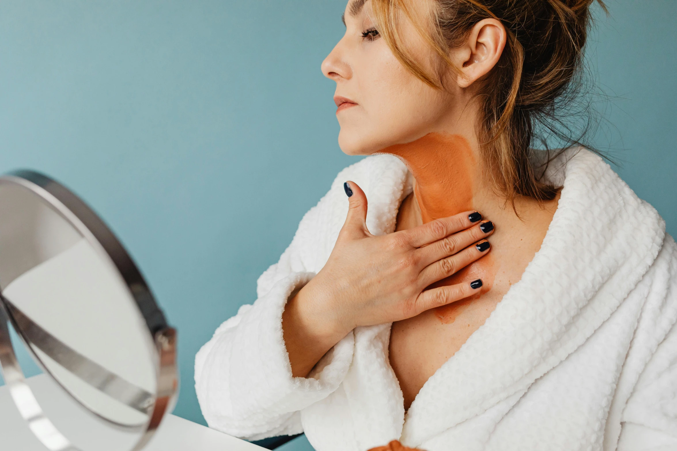 a woman in a bathrobe brushing her teeth in front of a mirror, a photo, by Julia Pishtar, trending on pexels, muscular neck, gordon freeman as a woman, candy treatments, blue scales covering her chest